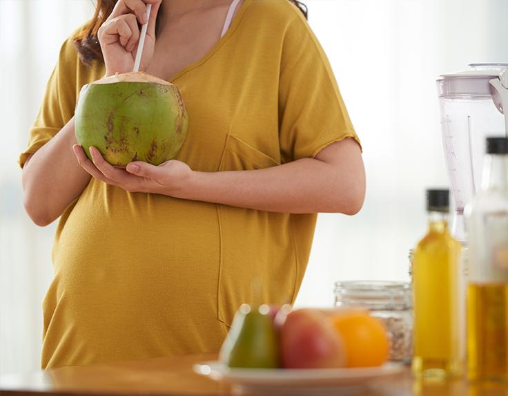 Pregnant women having coconut water to stay hydrated