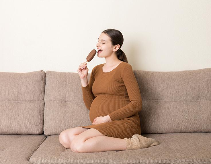 Pregnant woman is having ice-cream