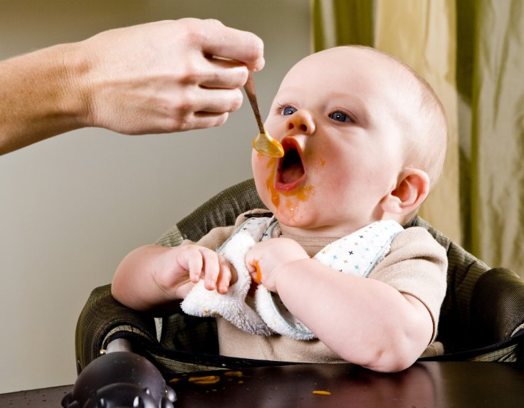 Mother is feeding 6 month old baby semi solid foods for baby
