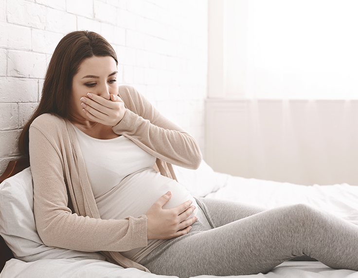 Woman experiencing morning sickness during first trimester